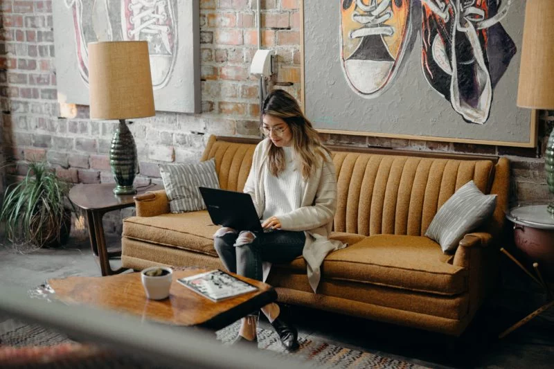 Katalog Model werden: Der beste Ratgeber für Einsteiger 5 frau sitzt auf dem sofa vor ihrem laptop und posiert als katalog model