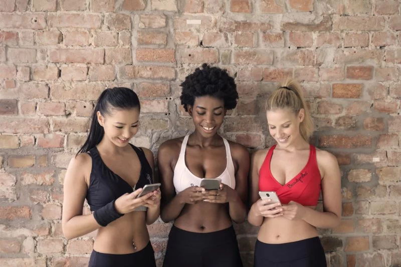 Fitness Model werden | Der ultimative Ratgeber 11 drei frauen mit handy in der hand