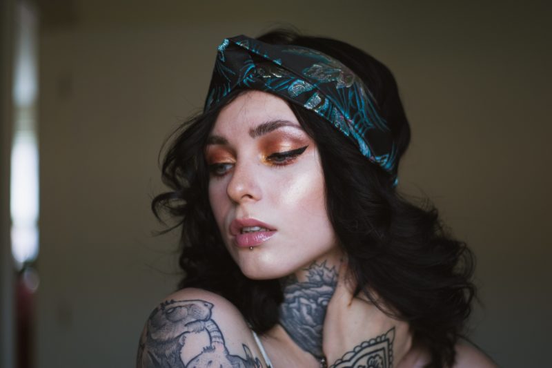 tattoo model mit kopfband und tattoos geschminkt