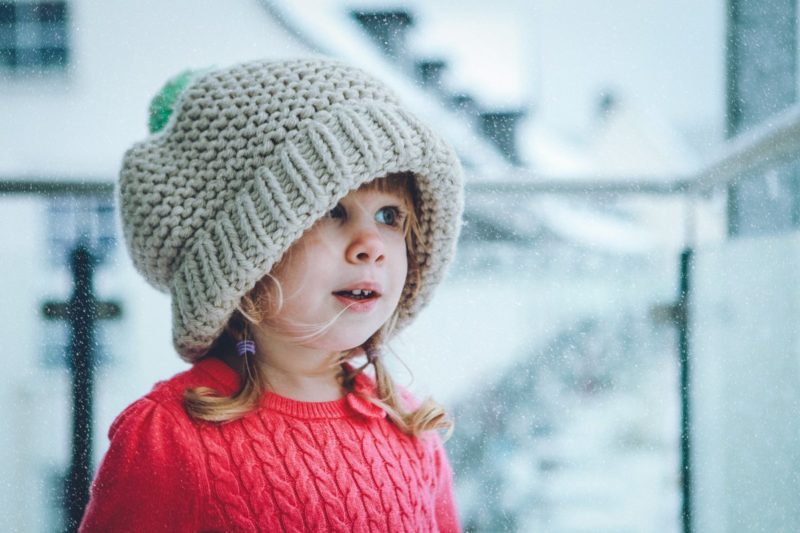 Kinderfotografie Porträt von einem Mädchen mit zu großer Mütze