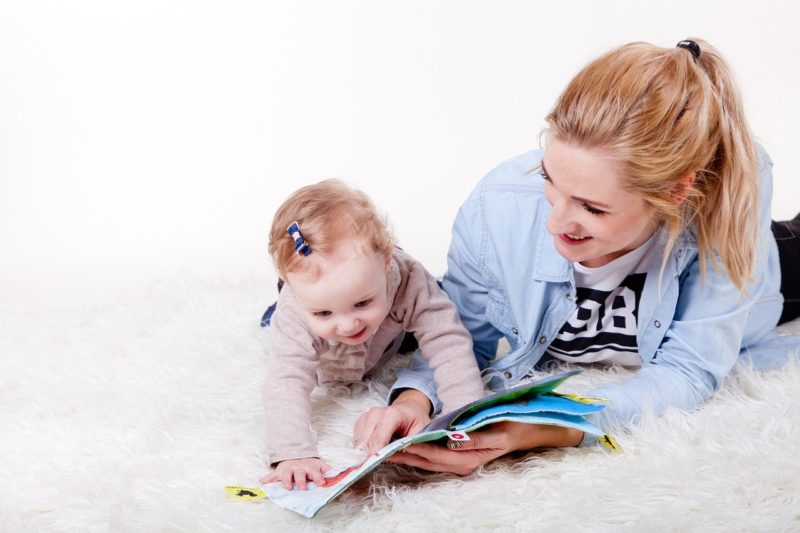 Kinderfotografie, Frau liest mit einem Baby ein Buch