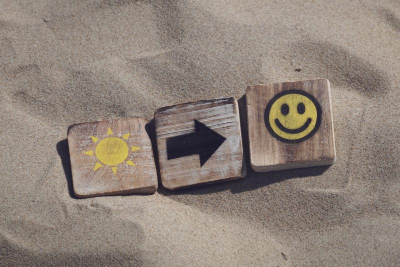 holztafeln mit emojis darauf liegend im sand