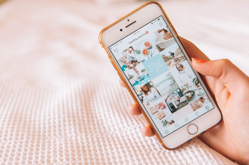 instagram influencer haelt iphone in der hand