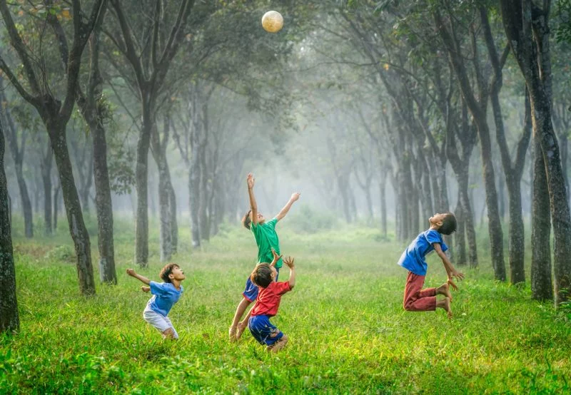 Inszenierte Fotografie vs. spontane Fotografie 4 vier jungen spielen in einer allee fussball