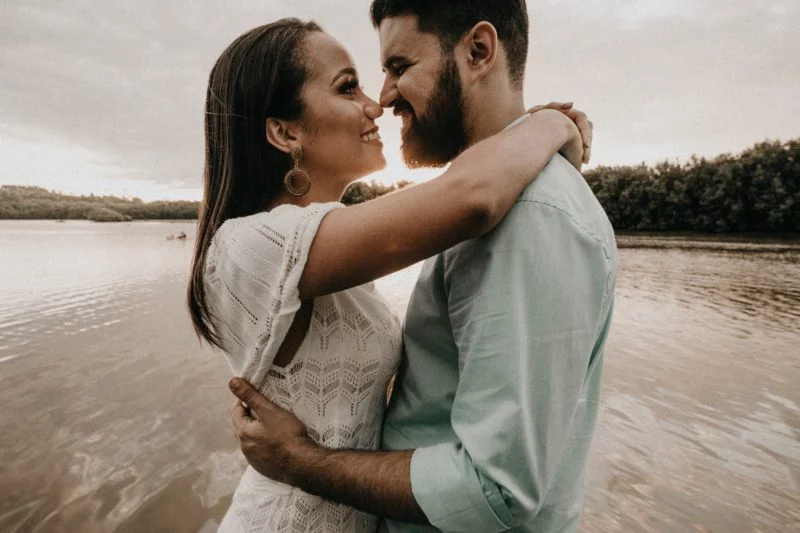 Inszenierte Fotografie vs. spontane Fotografie 7 inszenierte fotografie eine frau und ein mann umarmen sich am wasser und lächeln sich an