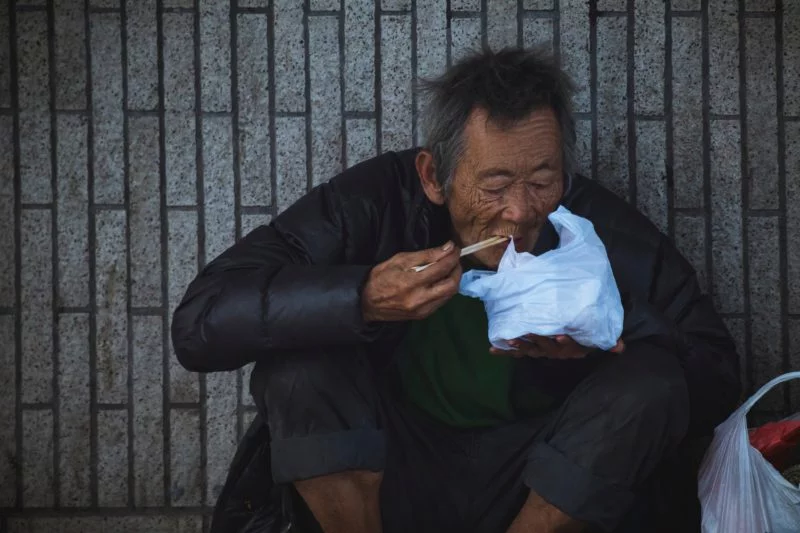 Inszenierte Fotografie vs. spontane Fotografie 2 spontanes bild eines essenden mannes auf der strasse