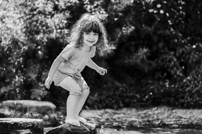 outdoorshooting mit kinder maedchen steht in der sonne und laechelt