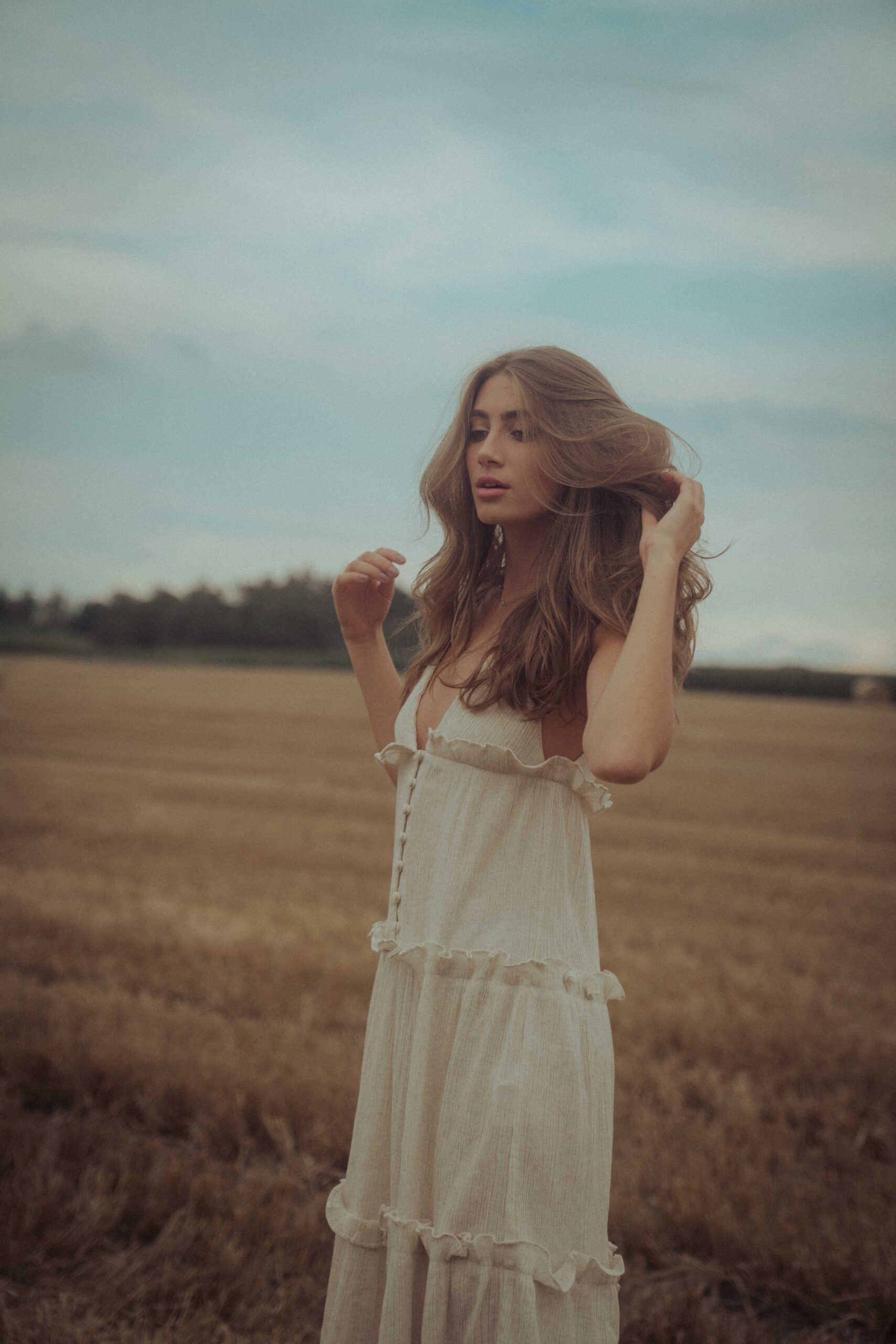 vintage portraits frau mit langen offenen haaren im nachthemd auf einem feld