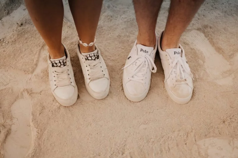 zwei paar turnschuhe stehen nebeneinander im sand