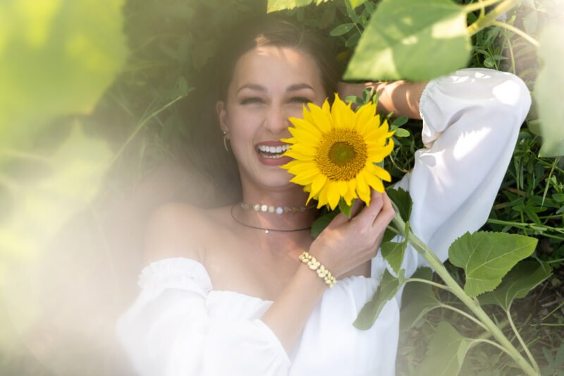 Peoplefotografie Frau mit Sonnenblume lachend