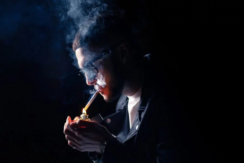 Mann mit Zigarette vor dunklem Hintergrund